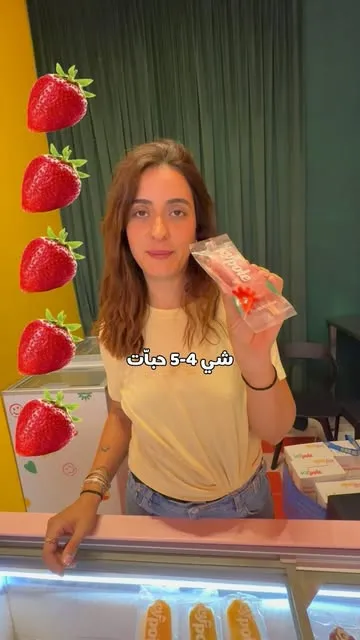 A strawberry IcyPole held up at the shop